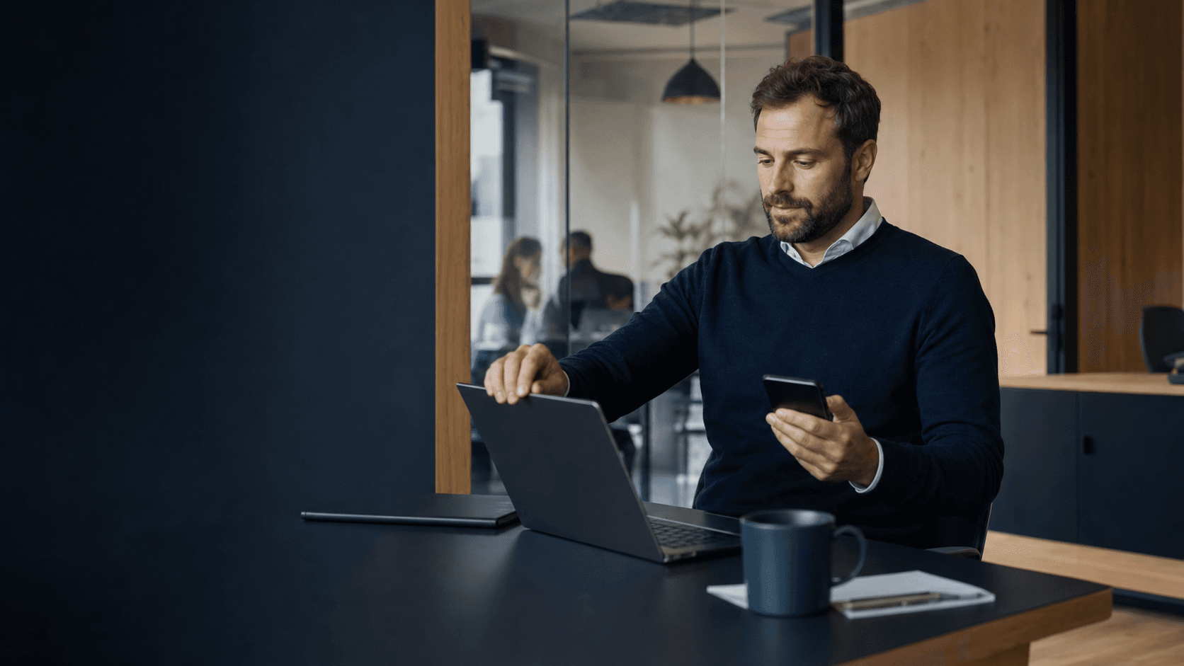 Mitarbeiter meldet sich mit Laptop und Smartphone sicher an